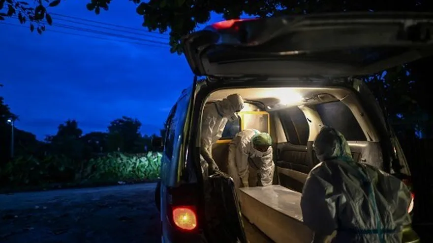 Voluntarios vestidos con ropa especial ayudan a sepultar los cadáveres no reclamados en Birmania