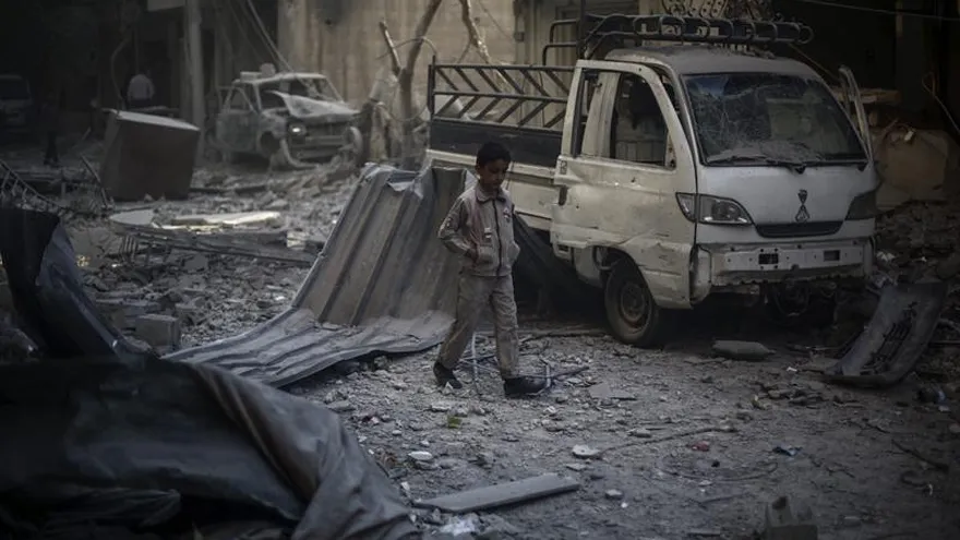 Un niño camina entre los escombros de edificios en ruinas tras un bombardeo de las fuerzas sirias leales al presidente Bachar al Asad en un barrio de Damasco.