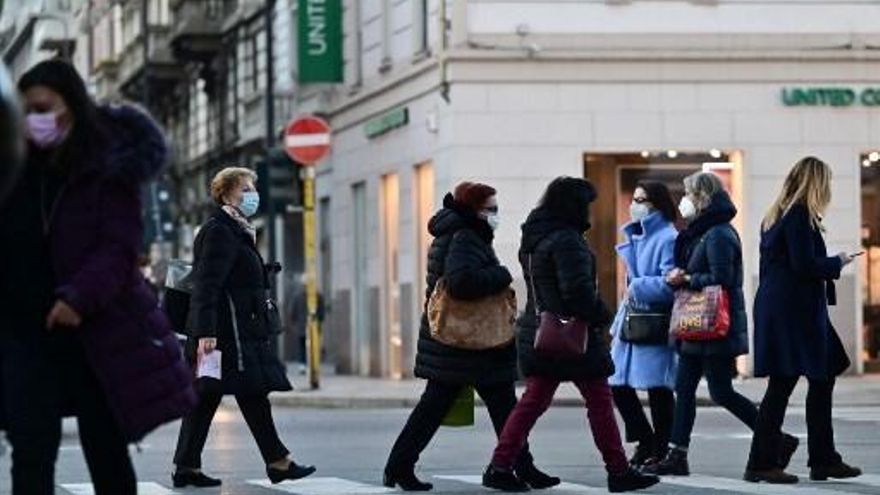 Personas caminan en una calle en Italia