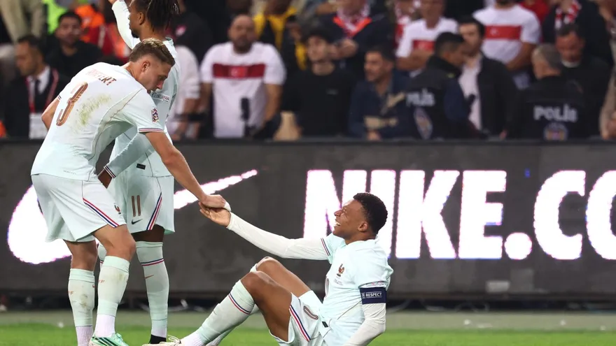 Kylian Mbappé (sentado) se queja de dolor en un intento por ponerse de pie durante el partido entre Francia y Turquía