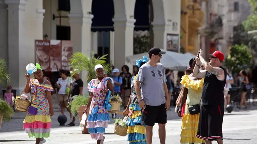 Varios turistas se toman fotos en una plaza de La Habana Vieja