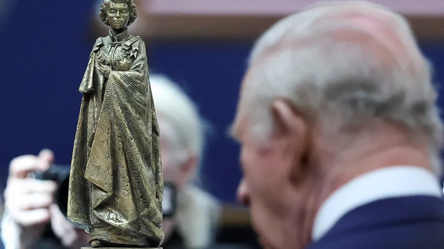 El rey Carlos III observa cómo será la estatua de bronce en el momunento homenaje a Isabel II