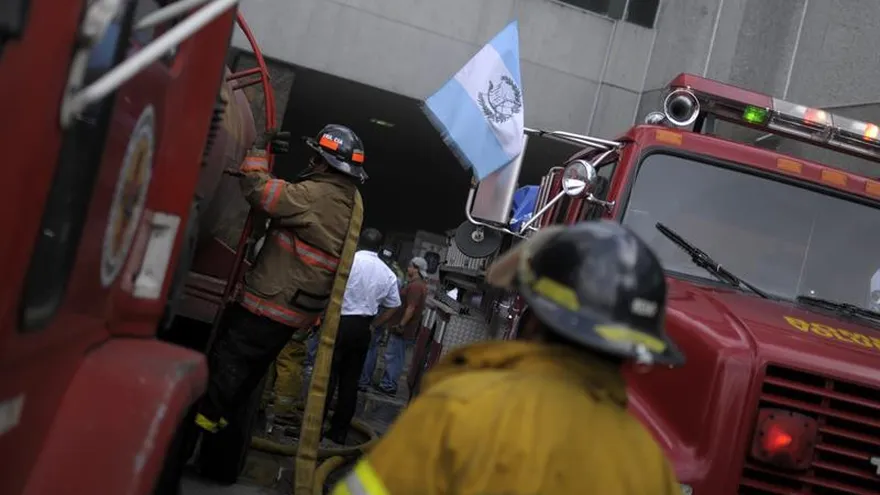 Bomberos municipales y voluntarios controlan un incendio.