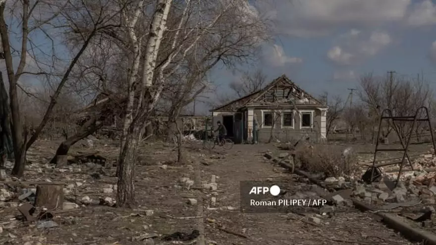Un hombre pasa en bicicleta junto a casas destruidas por los bombardeos en un pueblo cercano a la línea del frente, a las afueras de la ciudad de Pokrovsk, en la región oriental de Donetsk, el 20 de marzo de 2025, en medio de la invasión rusa de Ucrania.