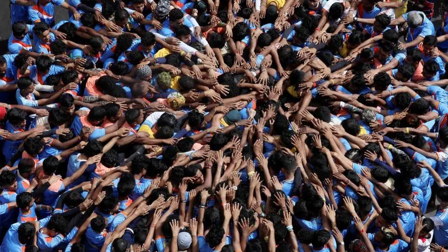 Devotos indios rezan antes de formar una pirámide humana para alcanzar y romper un "dahi-handi" (olla de barro) durante el festival Janmashtami, en Bombay.