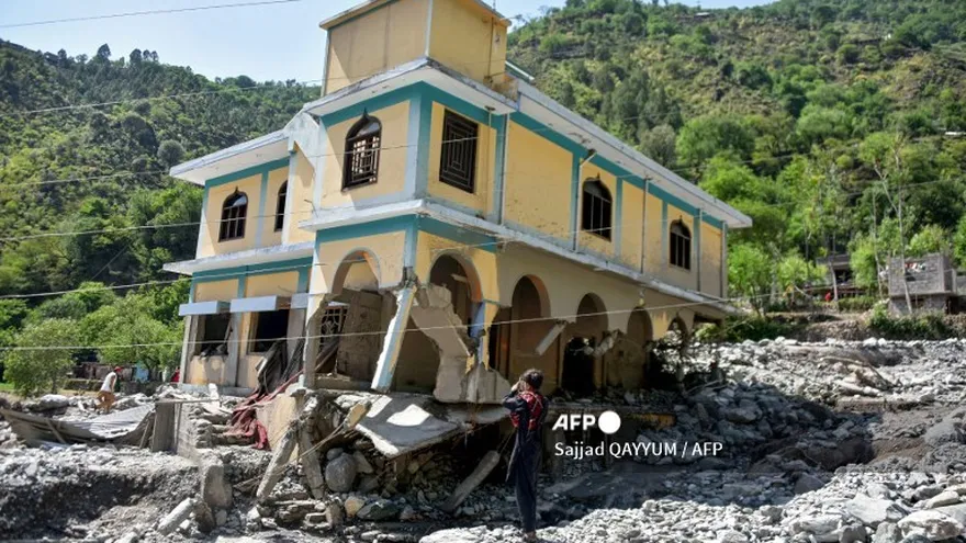 Una persona mira una vivienda dañada por las inundaciones