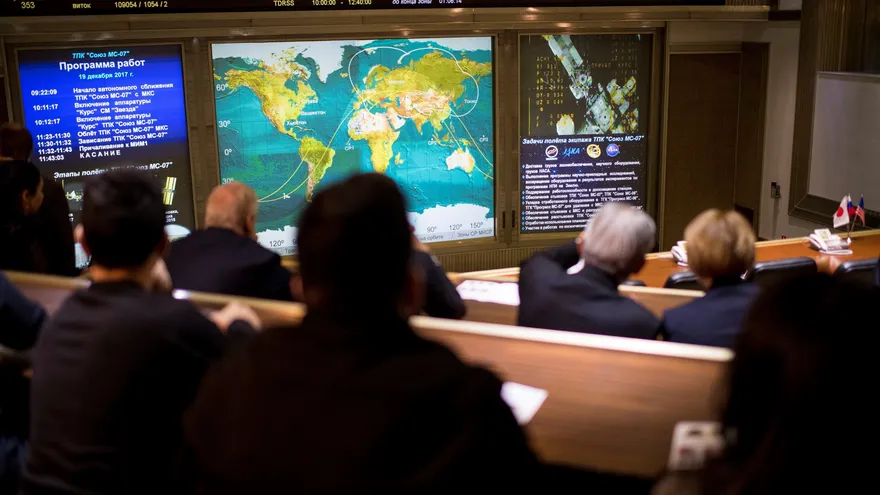 Familiares y amigos de los tripulantes de la nave rusa Soyuz MS-07 observan un mapa de seguimiento