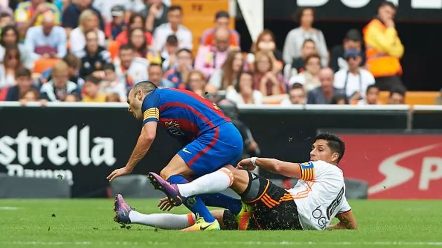 Andrés Iniesta (i) al momento de recibir la barrida de Enzo Pérez