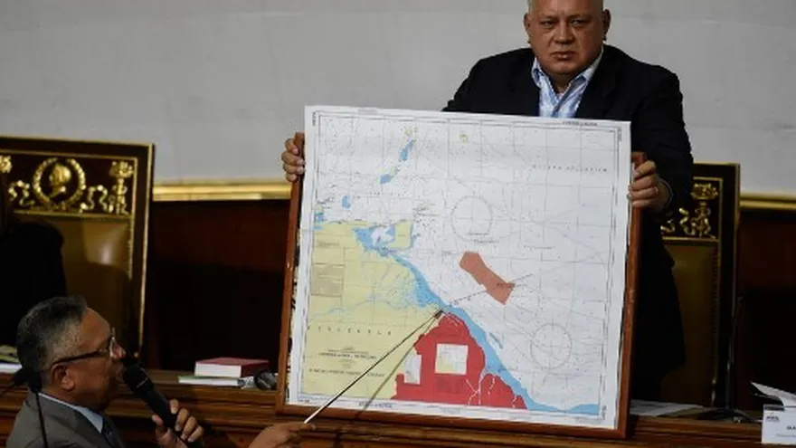 En esta foto de archivo tomada el 8 de enero de 2019, el miembro de la Asamblea Nacional Constituyente Pedro Careno (izq) pronuncia un discurso mientras el diputado venezolano Diosdado Cabello sostiene un mapa que muestra la frontera entre Venezuela y Guyana.