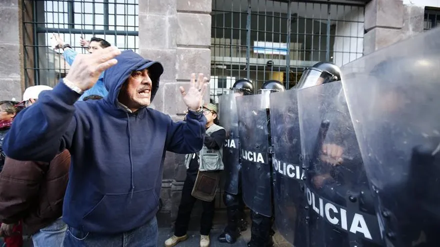 Seguidores del expresidente Rafael Correa fueron registrados este jueves al manifestar su apoyo al exmandatario, frente a un contingente policial, durante una marcha por las calles de Quito.