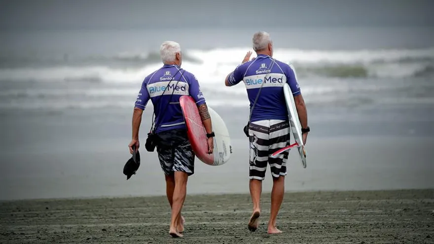 Dos hombres, adultos mayores practican surf