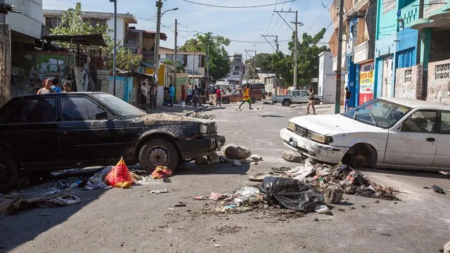 Dos automóviles quemados bloquean una calle el martes 20 de noviembre, en Puerto Príncipe, Haití.
