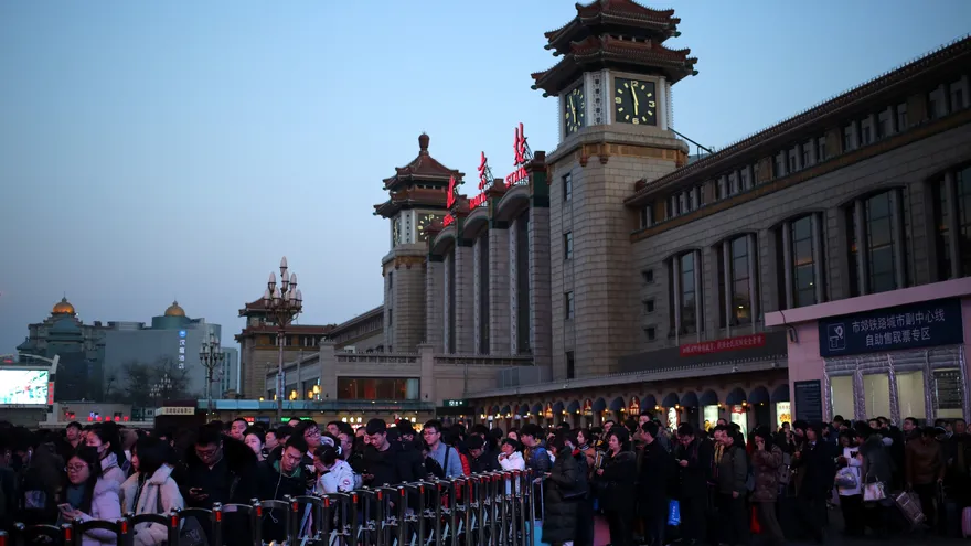 Numerosas personas hacen cola para acceder a la estación de trenes en Pekín, China.
