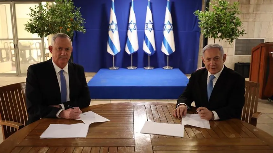 El primer ministro israelí, Benjamín Netanyahu (d), firma junto al centrista Beny Gantz (i) el acuerdo alcanzado este lunes mediante el cual Netanyahu seguirá siendo jefe de Gobierno israelí durante el primer año y medio de Ejecutivo unitario y que pondrá fin a más de un año de bloqueo político en el país