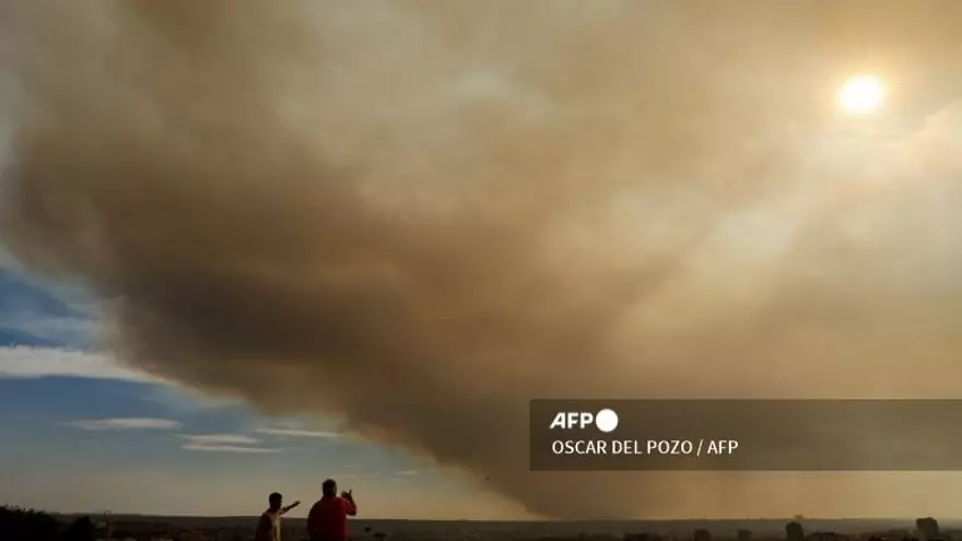 El humo de un incendio forestal en la provincia de Toledo tiñe el horizonte de un marrón anaranjado visto desde un parque en Madrid