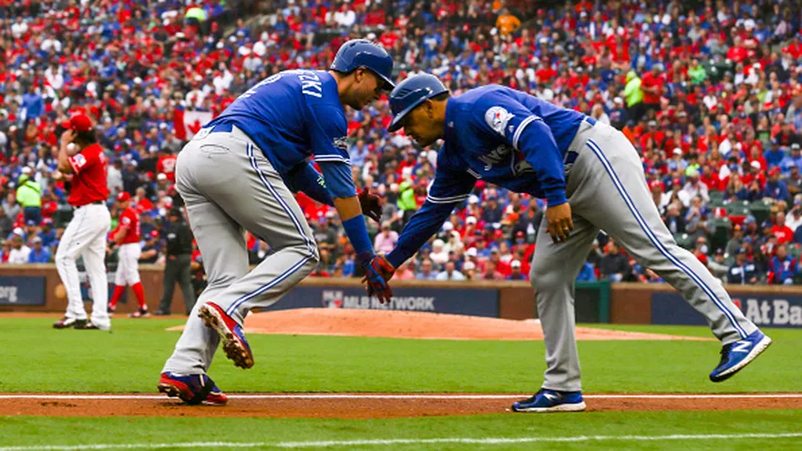 Troy Tulowitzki (i) celebra con el coach de tercera base Luis Rivera (d) el jonrón que le conectó a los Rangers