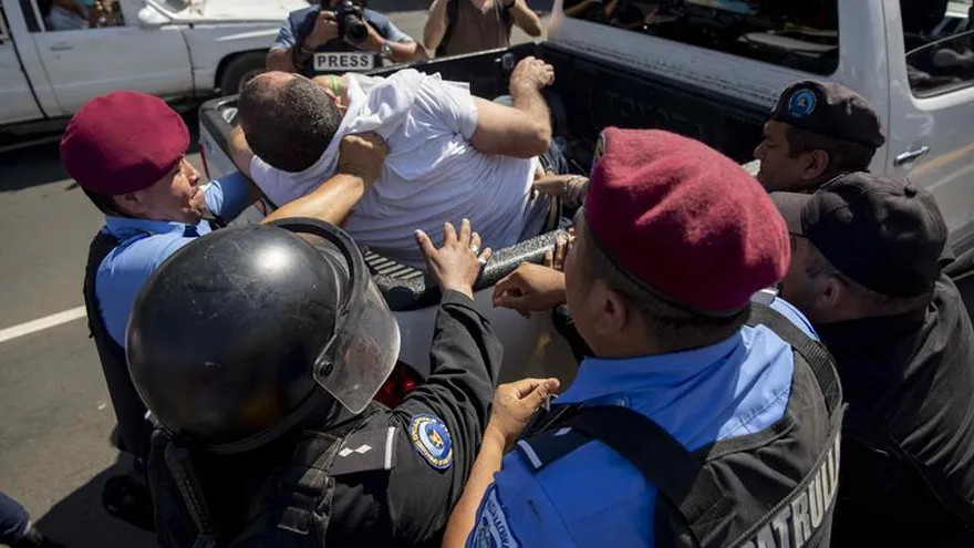 Policías detienen a un manifestante durante la marcha "Unidos Por la Libertad" en Managua (Nicaragua).
