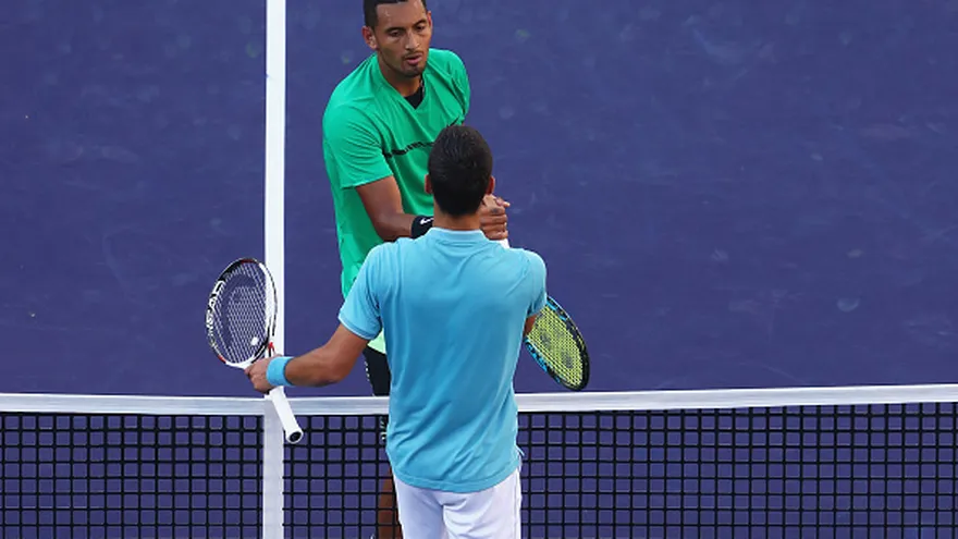 Nick Kyrgios (de frente) y Novak Djokovic (de espalda) se saludan