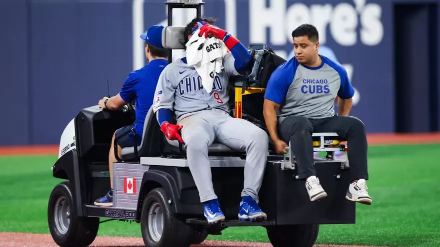 Miguel Amaya es retirado del terreno de juego en un vehículo durante el partido entre los Cachorros de Chicago y los Azulejos de Toronto