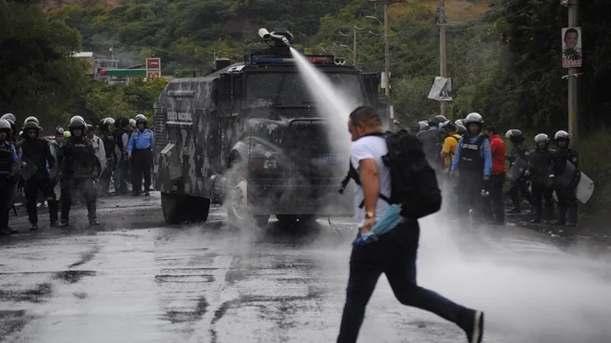 Policía de Honduras limpia los escombros producto de la toma de una carretera por parte de simpatizantes de la Alianza de Oposición contra la Dictadura hoy, jueves 7 de diciembre de 2017, en Tegucigalpa (Honduras).