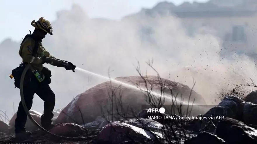 Un bombero apaga las llamas del incendio forestal en California.
