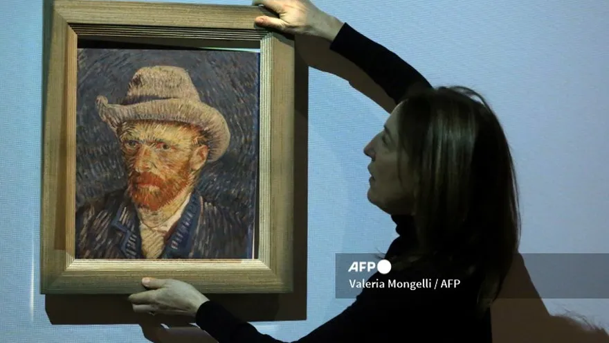 Emilie Gordenker, directora del Museo Van Gogh, quita el marco de una reproducción de la pintura "Autorretrato con Sombrero de Fieltro Gris" de Vincent Van Gogh.