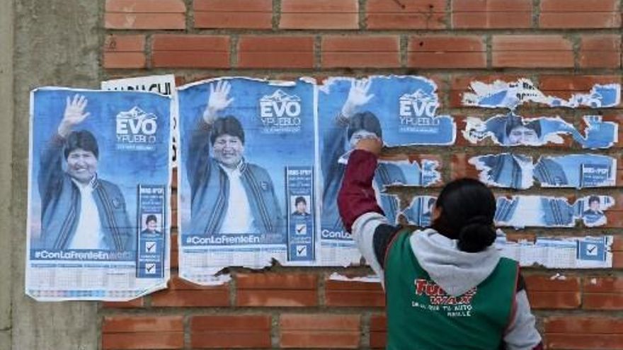 Una mujer quita una pancarta de Evo Morales