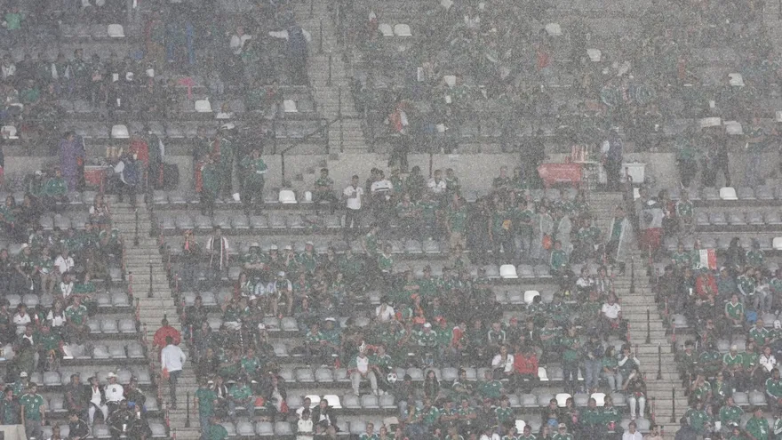 Fanáticos resguardados en las gradas mientras esperan el inicio del partido entre México e Inglaterra