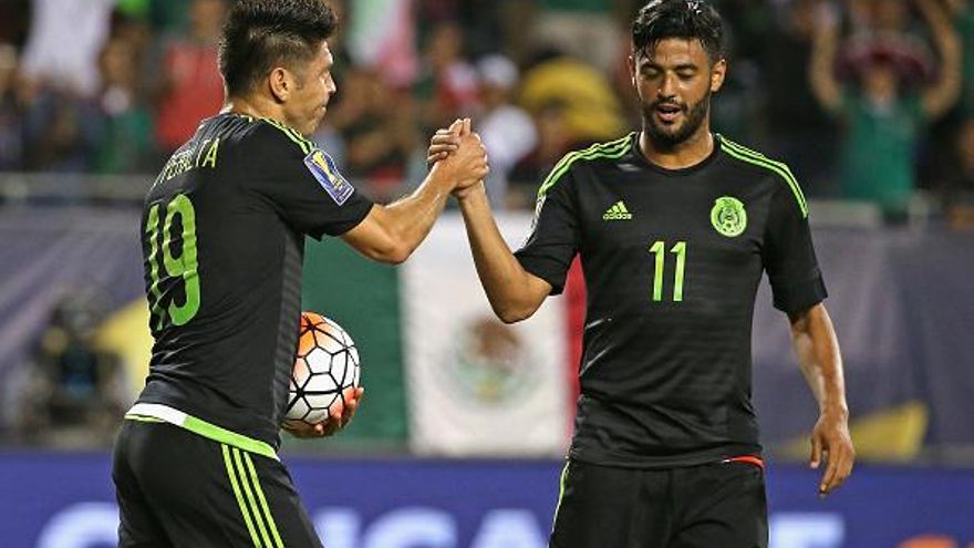 Oribe Peralta (i) es felicitado por Carlos Vela (d) al marcar uno de los goles del juego