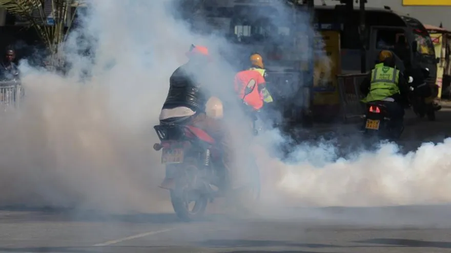 Simpatizantes de la Súper Alianza Nacional (NASA) y su líder Raila Odinga, circulan sobre una nube de gas lacrimógeno después de una redada policial para dispersarlos después de una manifestación en contra de la jura de la presidencia Raila Odinga, del partido Jubileo, en Nairobi (Kenia) hoy, 30 de enero de 2018.