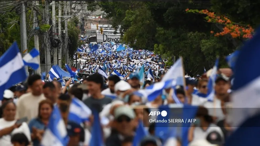 Simpatizantes del opositor Partido Nacional ondean banderas nacionales de Honduras durante una manifestación por la paz y la democracia en Tegucigalpa el 27 de julio de 2025