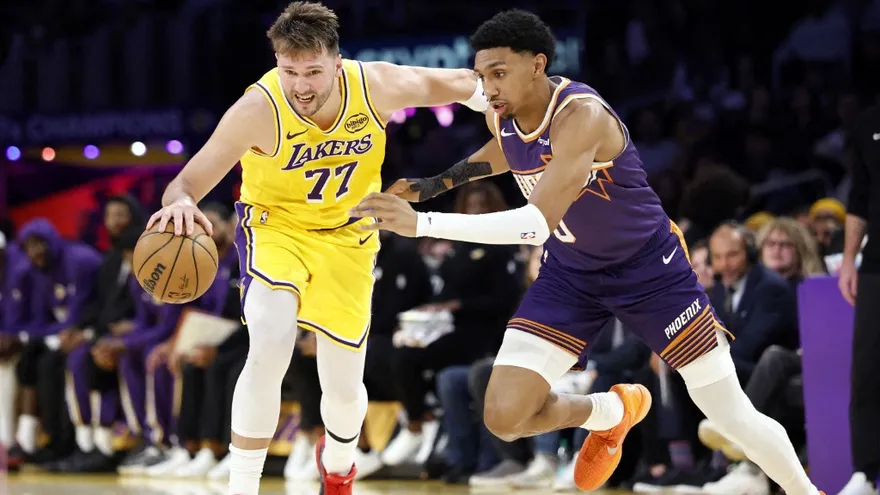 Luka Doncic (i) trata de evadir la cobertura defensiva de Ryan Dunn (d) durante el partido entre los Lakers y los Suns