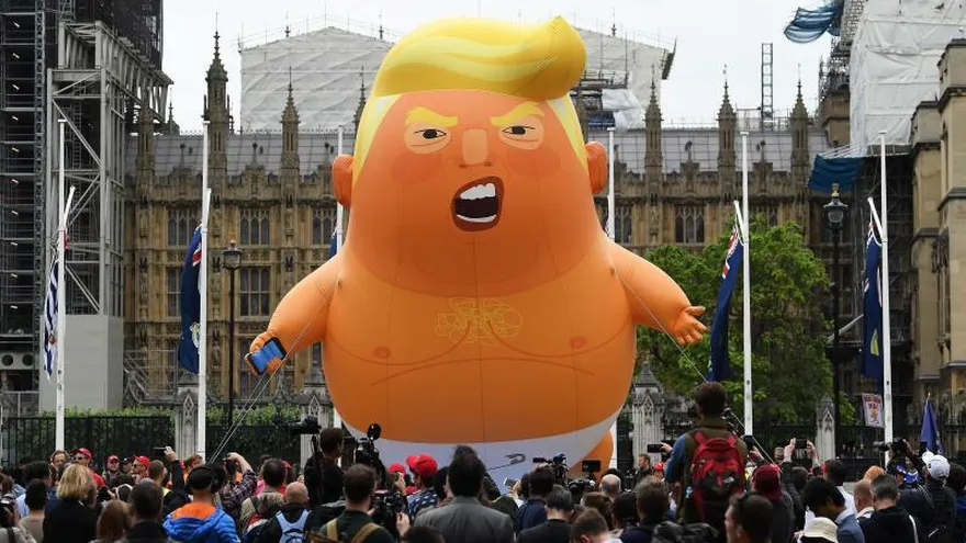 Decenas de manifestantes rodean un globo gigante que caricaturiza al presidente de Estados Unidos, Donald Trump, durante una protesta contra la visita del mandatario, este martes en Londres (Reino Unido). "Juntos contra Trump" es el lema de una multitudinaria movilización convocada hoy en la céntrica plaza de Trafalgar Square.