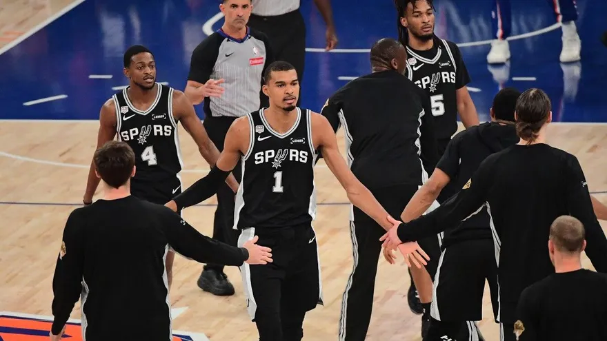 Victor Wembanyama saluda a algunos de sus compañeros de los Spurs