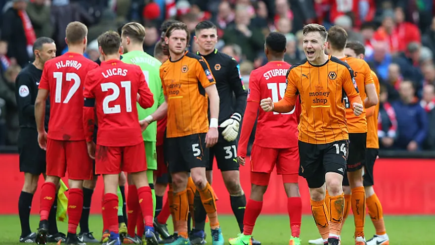 Jugadores del Wolverhampton celebran ante la tristeza de algunos integrantes del Liverpool