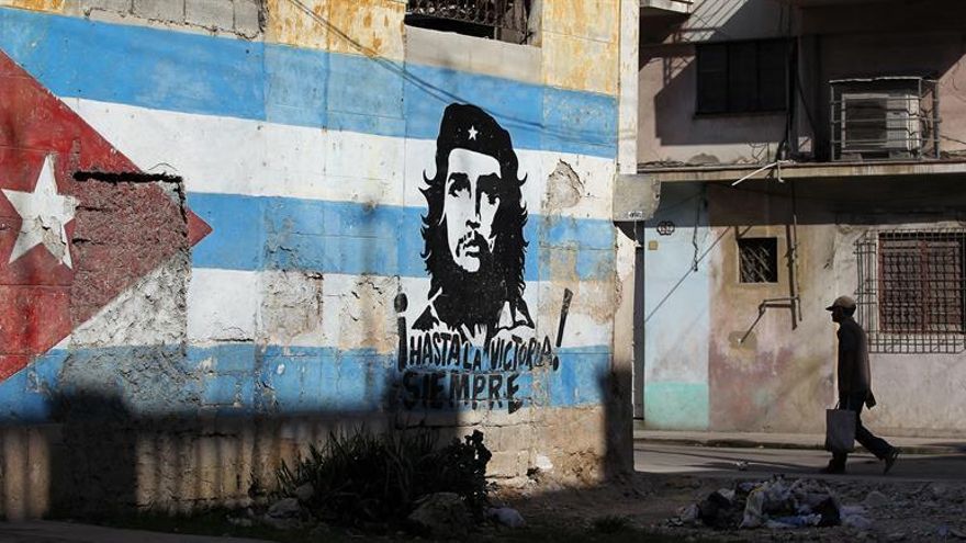 Un hombre camina junto a un muro con una bandera cubana y la imagen del Che Guevara, el pasado miércoles 15 de abril de 2015, en una calle de La Habana (Cuba).