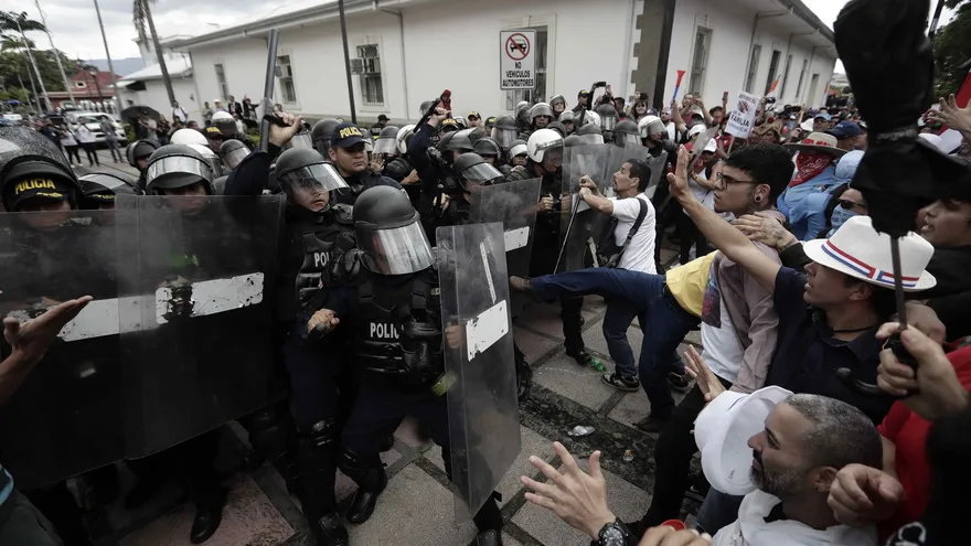 Manifestantes se enfrentan con la policía durante una marcha por las principales avenidas de San José (Costa Rica)