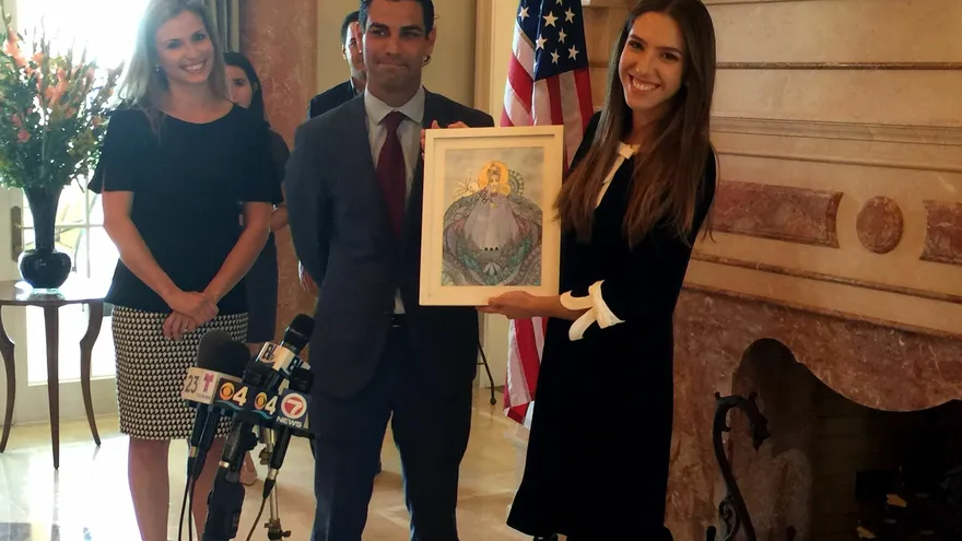 El alcalde de Miami, Francis Suárez (c), acompañado de su esposa Gloria Fonts (izq), entrega a Fabiana Rosales (dcha), la esposa del líder opositor venezolano Juan Guaidó, un cuadro elaborado por la activista y exiliada cubana Ninoska Pérez Castellón