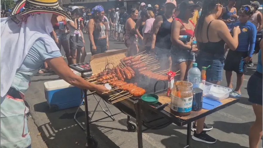 Una vendedora de carnes, brochetas y chorizo en palito.