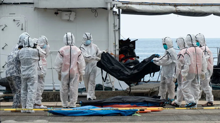 Personal de la Guardia Costera filipina, con trajes protectores, descarga bolsas para cadáveres de las víctimas del incendio de un ferry en el puerto de Borac, en Coron, provincia de Palawan, el 12 de septiembre de 2026.