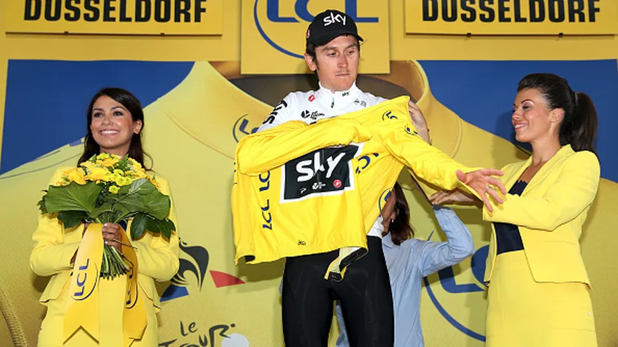Geraint Thomas (c) se coloca el maillot amarillo