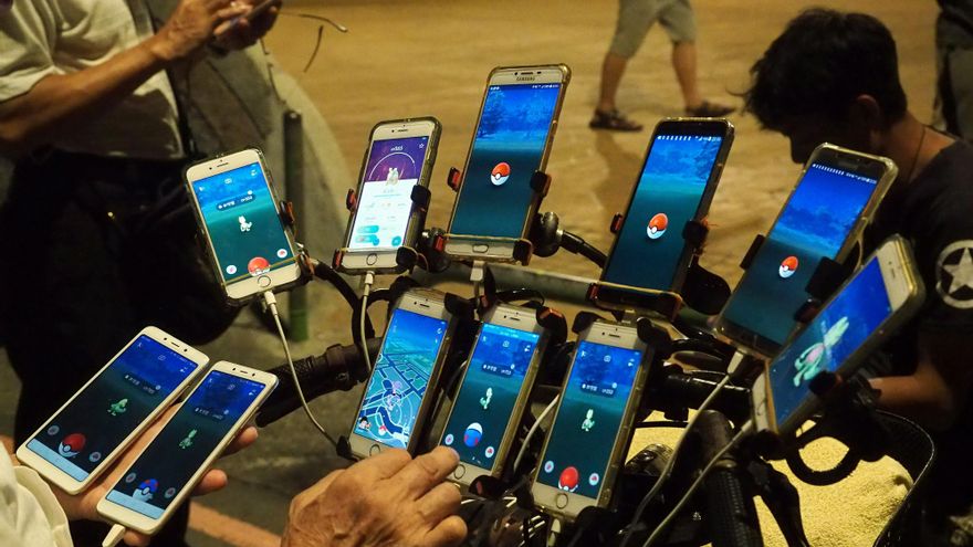 El taiwanés Chen San-yuan, de 59 años, transporta 11 teléfonos móviles en su bicicleta y una bolsa con baterías para jugar a la aplicación Pokemón Go, en Taipei (Taiwán)
