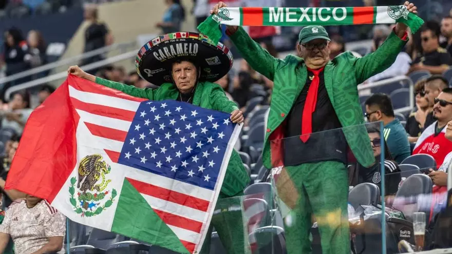 Fanático mexicano (i) con una bandera conjunta de México y Estados Unidos