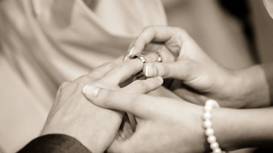 Foto ilustrativa: Una mujer coloca el anillo de bodas a su pareja