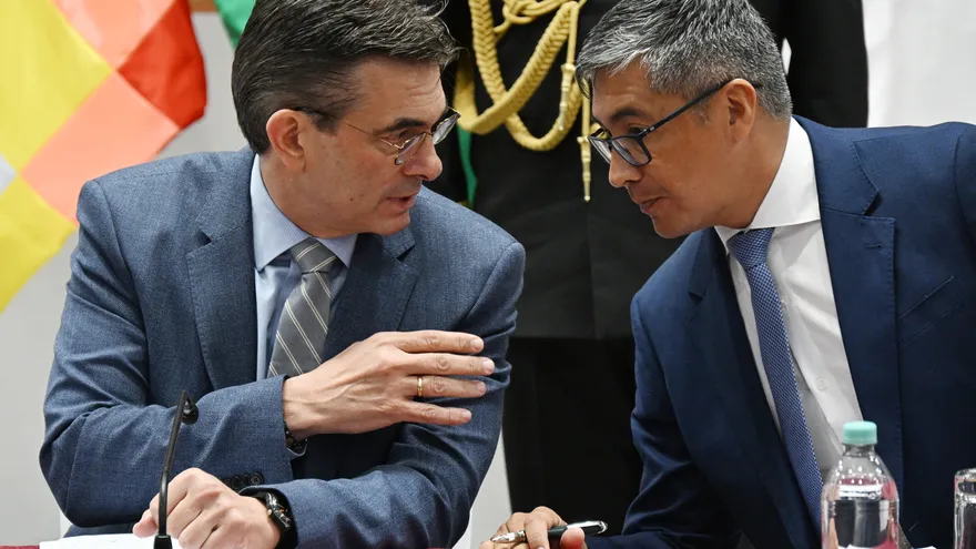 El presidente de Bolivia, Rodrigo Paz (izq.), conversa con su ministro de Economía, José Gabriel Espinoza, durante una conferencia de prensa.