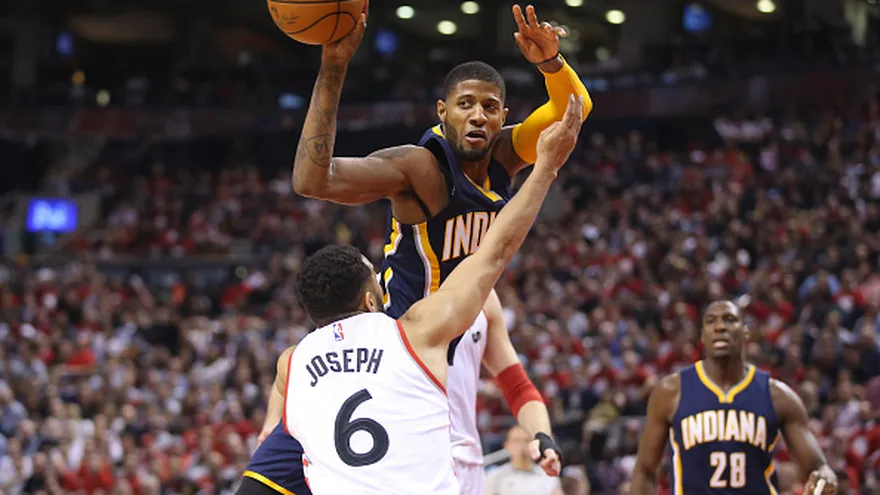 Paul George (de frente) es cubierto por Cory Joseph (de espalda)