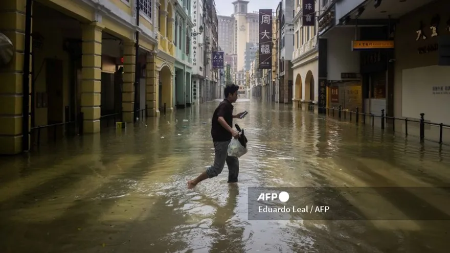 Una persona camina en medio de una calle inundada en Macao, China