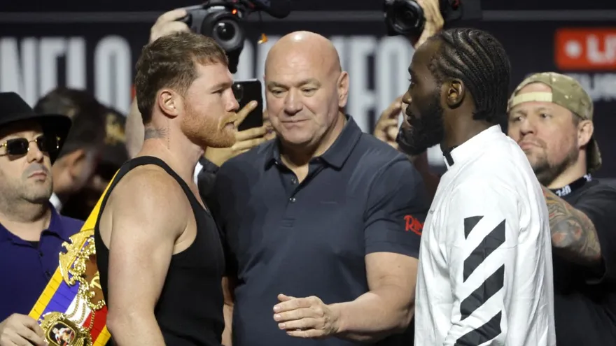 Saúl 'Canelo' Ávarez (i) y Terence 'Bud' Crawford (d), separados por el empresario Dana White (c)