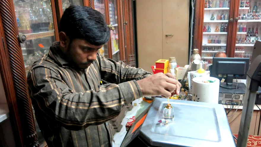 Un perfumista trasvasa una fragancia en la perfumería Gulab Singh Johrimal de Nueva Delhi, fundada en 1816, el 21 de diciembre de 2017