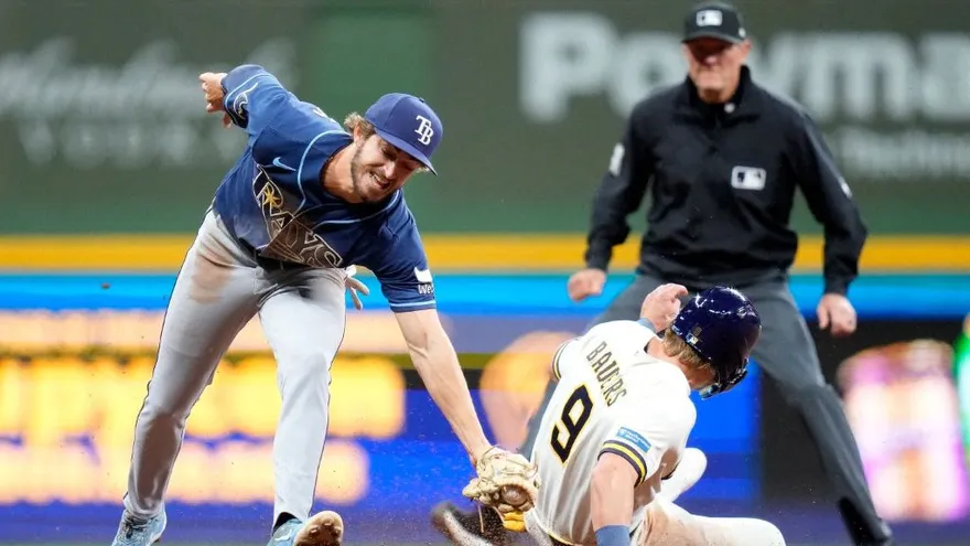 Carson Williams (i) trata de poner out en la segunda base a Jake Bauers (d)